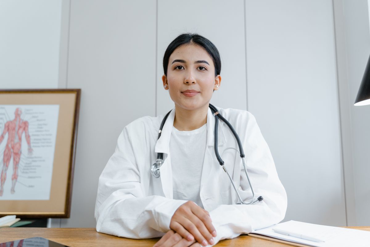 Médica en su consultorio, con fonendoscopio, atendiendo en la sede
